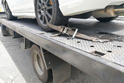 Car,Tire,Secured,With,Belt,For,Safety,On,Flatbed,Tow