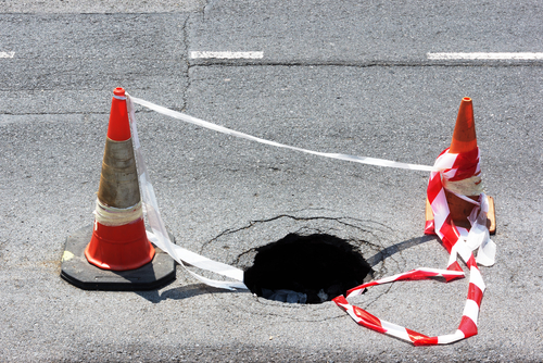 Road,Hole,With,Warning,Cones,And,Tape