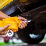 Hands,Of,Man,Holding,Yellow,Car,Towing,Strap,With,Yellow